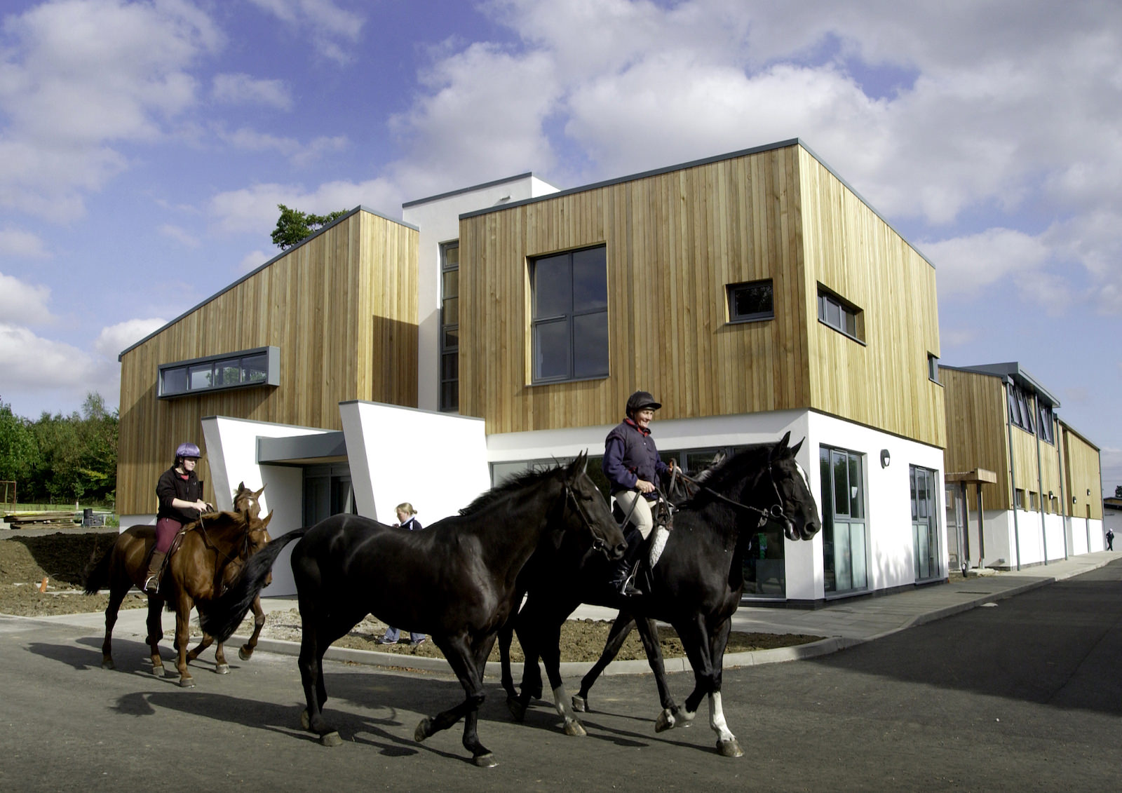 external view of the riseholme equine centre with people enjoying riding horses